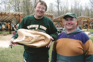 Brian, Instructor, showing one of the students a butternut eagle relief carving demonstrated during the class